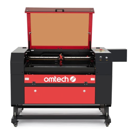 OMTech enclosed CO₂ laser engraver and cutter with the lid open, showing the engraving bed and laser carriage