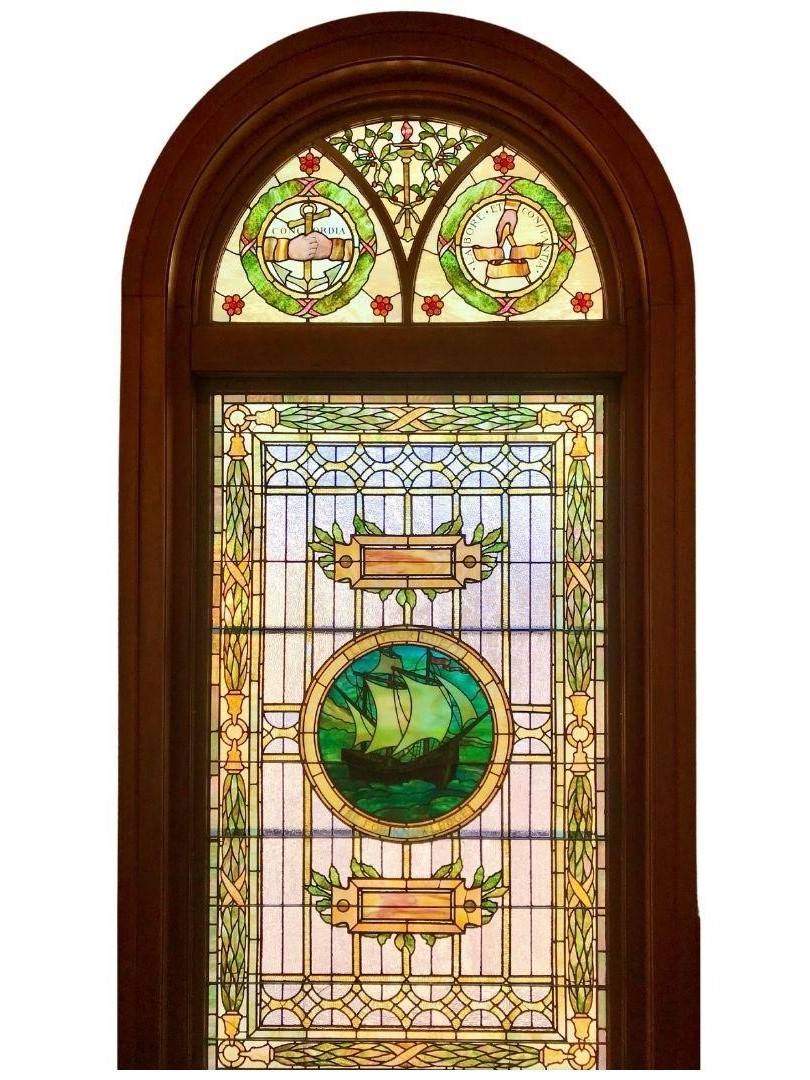 The stained glass window in the main stair landing of the Jubal Howe Memorial Library.