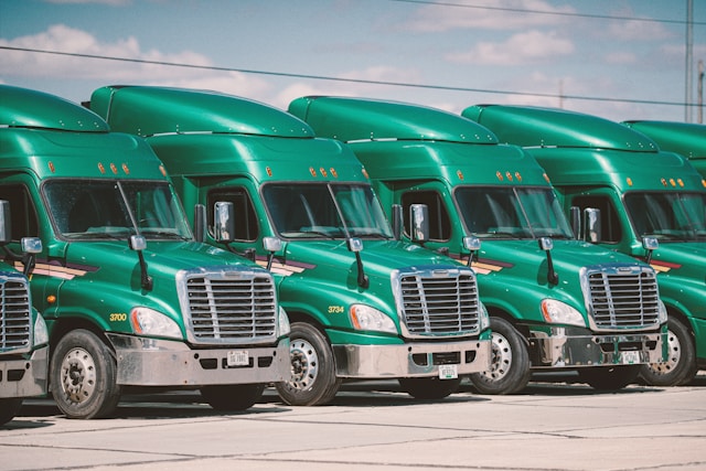 Row of green semi-trucks,photo by Brian Stalter on Unsplash